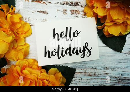 Hello Holiday Card with Blooming flower on wooden background Stock Photo