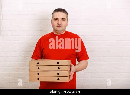 Portrait of young delivery man holding cardboard boxes. Stock Photo