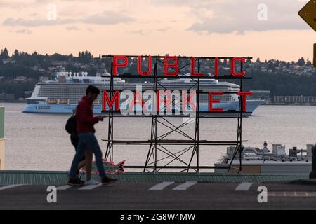 Seattle, USA. 21 Jul, 2021. Royal Caribbean Ovation of the Seas cruise ship and the Pike Place Market neon sign with tourists. Stock Photo