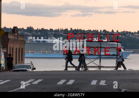 Seattle, USA. 21 Jul, 2021. Royal Caribbean Ovation of the Seas cruise ship and the Pike Place Market neon sign with tourists. Stock Photo