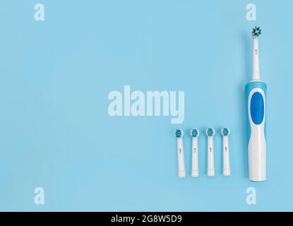 Modern electric toothbrush set with replacement heads on flat lay background. Concept of professional oral care and healthy teeth by using smart sonic Stock Photo
