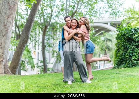 Three cheerful mature female friends standing hugging together Stock Photo