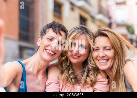 Portrait of three adult female friends taking a selfie in the city Stock Photo
