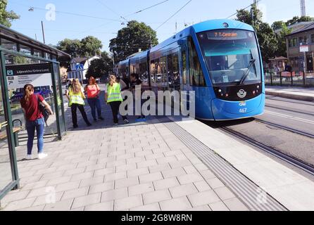 Stockholm, Sweden - July 21, 2021: Modern tram in setvoce on line 7 arriving the stop at Grona Lund. Stock Photo