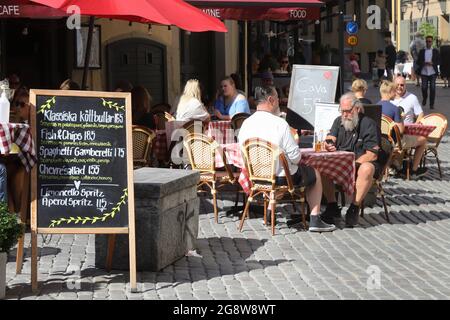 Stockholm, Sweden - July 21, 2021: Menu in front of people sitting at the restaurant outdoor seating located at the Jarntorget square in the Old town Stock Photo