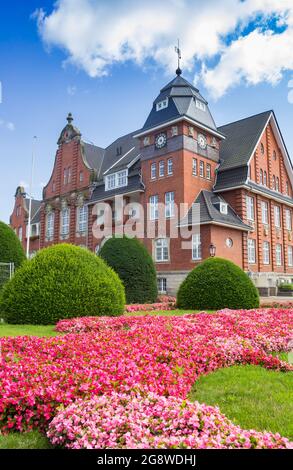 Pink flowers in front of the historic town hall of Papenburg, Germany Stock Photo