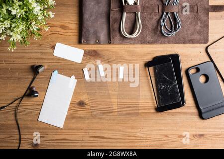 new screen protector film and broken tempered glass screen protector for smartphone on wooden desk Stock Photo