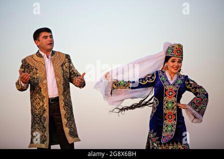 Uzbek man and woman in national costumes dancing and singing in Bukhara, Uzbekistan Stock Photo