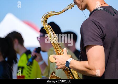 Crop man playing saxophone on street Stock Photo
