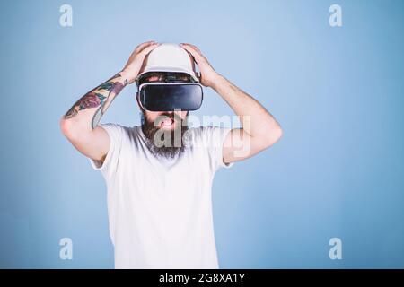 Guy in helmet works as engineer in virtual reality. 3D design concept. Architect or engineer with virtual reality glasses. Man with beard in VR Stock Photo