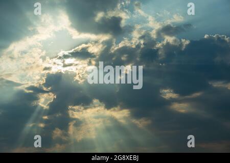 The sun behind the clouds and the sun's rays, summer day Stock Photo