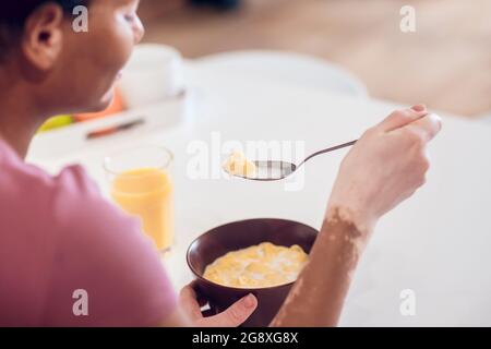 Dark-skinned young woman having breakfast at home Stock Photo