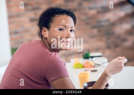 Dark-skinned young woman having breakfast at home Stock Photo