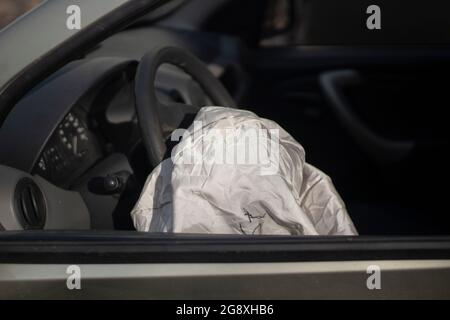 The airbag has deployed. Car after an accident. The driver's seat is distorted. Safety device in the car. Stock Photo