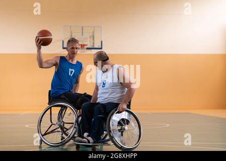 handicapped war veterans in wheelchairs with professional equipment play basketball match in the hall.the concept of sports with disabilities Stock Photo