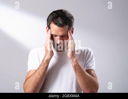 Man using a facial oil to massage in to his skin. Stock Photo