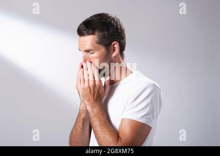 Man using a facial oil to massage in to his skin. Stock Photo