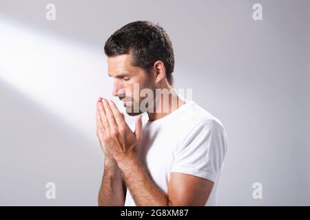 Man using a facial oil to massage in to his skin. Stock Photo