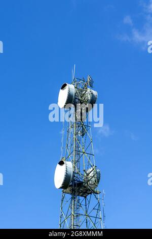 Microwave antenna Telephone pole technology mobile telephone network base station telecommunication tower  on blue sky background - bottom view Stock Photo