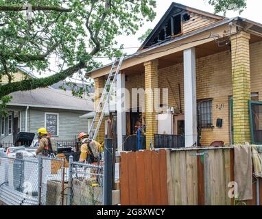 NEW ORLEANS, LA, USA - JULY 20, 2021: Firemen, ladder and burnt out building in Central City Stock Photo