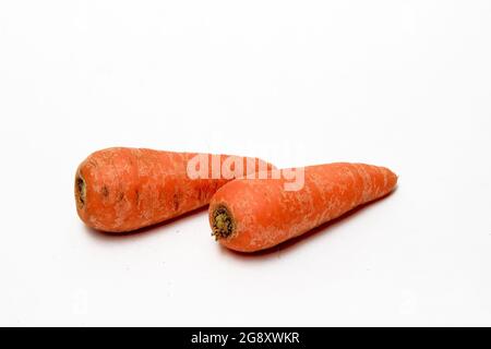Two carrots, which are a rich sources of beta-carotene and fiber, isolated on a white surface Stock Photo