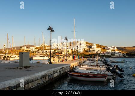 LOUTRA, Kythnos, Greece, 03.06.2019. Row of sailing and fishing boats moored at the pier in Loutra Marina Kythnos, Cyclades Islands, sunset. Stock Photo