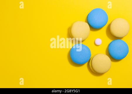 macaroni cookies laid out in a circle on a bright yellow background with copy space Stock Photo