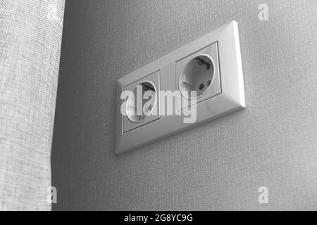 Double European electrical socket on wall at home in modern design, gray wall color Stock Photo