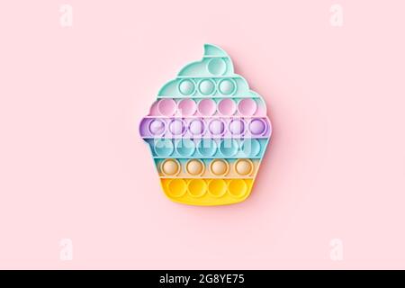 Popit toy in the form of a cupcake on a pink background, top view Stock Photo