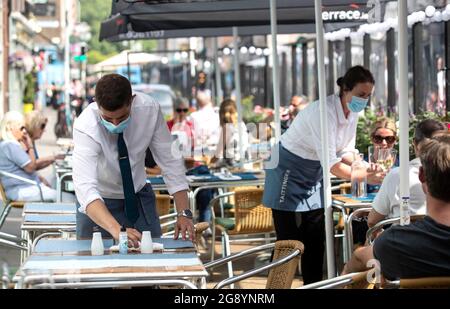 A waiter sets a table outside Hugo’s restaurant on Merrion Row in Dublin, where they will reopen for indoor dining on Thursday July 29. Picture date: Friday July 23, 2021. Stock Photo