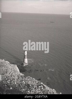 1950s, historical, aerial view of the off-shore Lighthouse below the cliffs at Beachy Head, Eastbourne, East Sussex, England, UK. A granite tower, erected in 1902 to replace the Belle Tour lighthouse on the top of the cliffs, it was the last traditional-style 'rock tower' to be built in England. Stock Photo