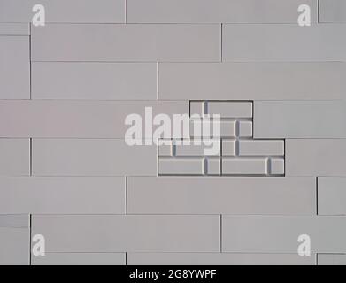 Close-up of wall made from gray plastic blocks with bricks in the middle. Stock Photo
