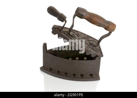 Antique open iron for ironing with hot coals in cast iron with wooden handle isolated on white Stock Photo