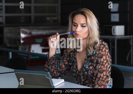 Thoughtful female freelancer using digital tablet in cafe Stock Photo