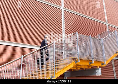 Businessman walking up on staircase near building Stock Photo