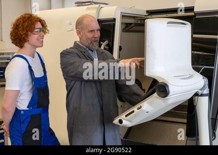 Mature male instructor guiding young technician at industry Stock Photo