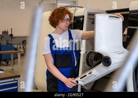 Male technician wearing protective eyewear using machinery while working at workshop Stock Photo