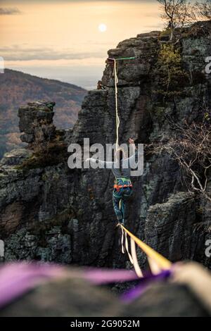 Mid adult woman balancing while highlining in mountains during sunset at Baden-Baden, Germany Stock Photo