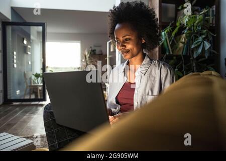 Young female freelancer using laptop while working at home Stock Photo