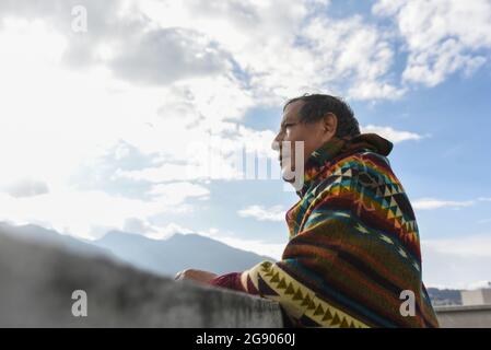 Thoughtful man wearing poncho looking away at rooftop Stock Photo