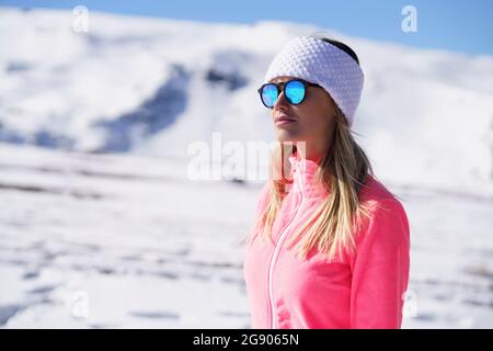Beautiful woman wearing sunglasses looking away on sunny day Stock Photo