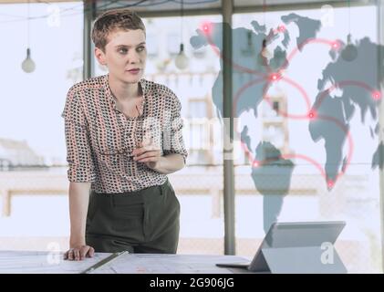 Businesswoman leaning at desk while looking at networking data Stock Photo