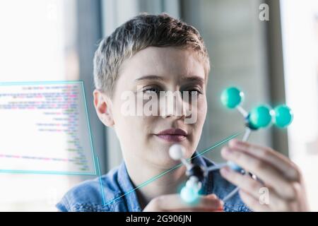Businesswoman looking at molecular structure at office Stock Photo