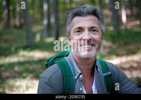 Smiling handsome male hiker with gray hair and stubble Stock Photo