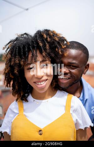 Multi-ethnic young couple smiling during sunny day Stock Photo