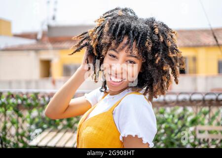 Afro woman with head in hands in balcony Stock Photo