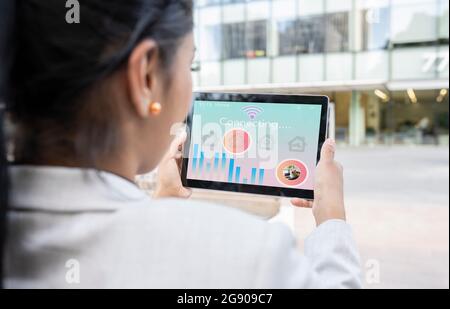 Businesswoman using digital tablet with house icon Stock Photo