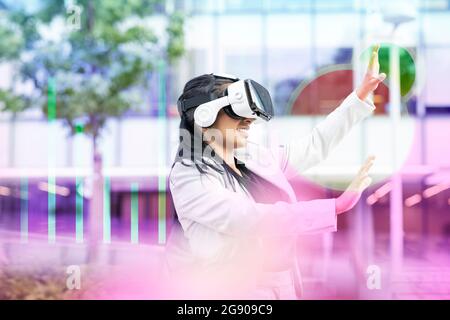 Businesswoman using virtual reality headset Stock Photo