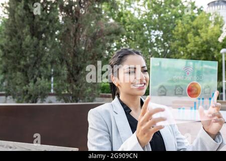 Female professional using transparent futuristic tablet Stock Photo