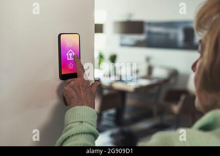 Woman touching wifi icon on home automation device Stock Photo